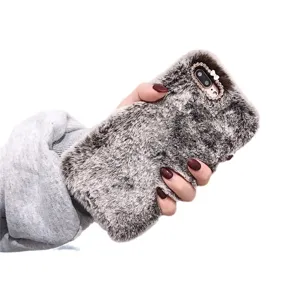 Fluffy faux fur phone case with sparkling rhinestone bow camera protection for stylish users.