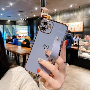 Electroplated heart phone case with wrist strap stand, compatible with Apple iPhone models.