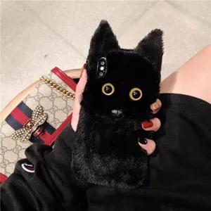Close-up of a fluffy black cat phone case with big yellow eyes, soft plush texture.