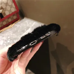 Detailed view of the black plush phone case, showing precise bottom cutouts and fluffy texture.