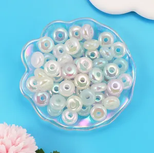 Closeup of colorful iridescent acrylic donut spacer beads for DIY handmade jewelry crafting.