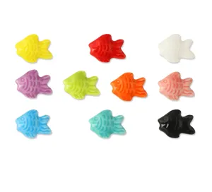 Dettaglio di perline di pesce rosso in ceramica colorata, perfette per gioielli fai da te.