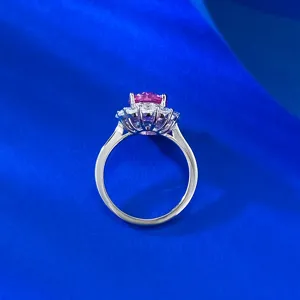 Primo piano dettagliato di un anello ovale con pietra rosa e alone di pietre bianche.