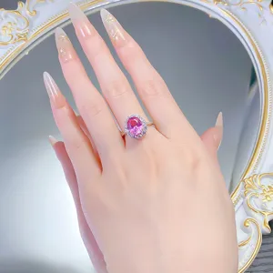 Primo piano dell'anello in zaffiro rosa ovale con alone di zirconi, elegante fascia in argento.