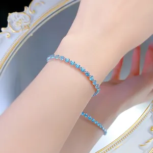 Nahaufnahme des glitzernden hellblauen Zirkonia Tennisarmbands am Handgelenk präsentiert.