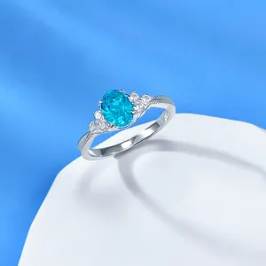 Silber Paraiba Edelstein Ring Detail, oval blauer Stein mit Seitensteinen, feiner Perlenrand.