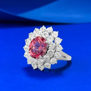 Nahaufnahme eines doppelten Halo-Clusterrings mit einem lebendigen ovalen Padparadscha-Stein.