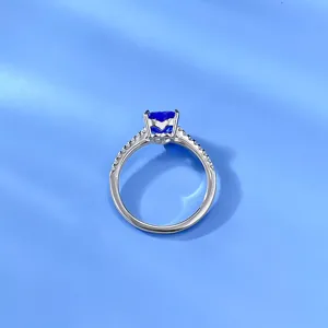 Primo piano dettagliato di un anello con gemma blu a cuore con montatura in pavé di zirconi.