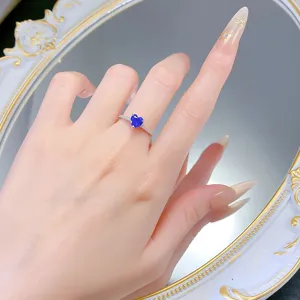 Primo piano dettagliato di un anello in argento sterling con gemma blu a cuore e delicato pavè.