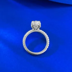 Close up detail shot of the elegant oval moissanite ring with pave band and sparkling stone.