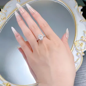 Detail shot of an elegant oval cut moissanite ring with half pave band and classic four prongs.