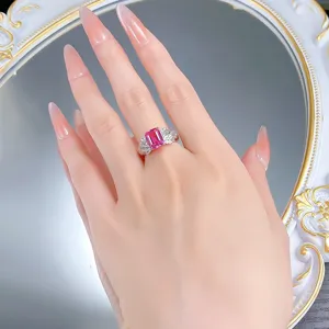 Detailed close-up view of emerald-cut pink sapphire ring with delicate carved 925 silver band.