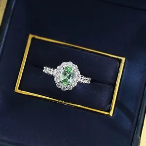 Detailansicht des S925 Silber ovalen grünen Edelsteinrings mit Halo und verziertem Perlenband.