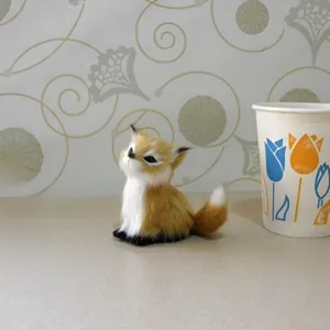 Vue détaillée d'un charmant renard en peluche assis gracieusement sur une surface propre.