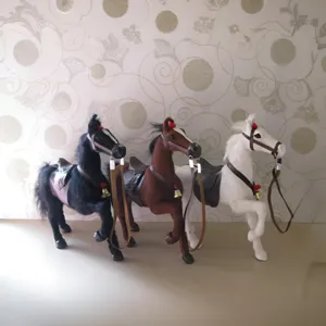 Detailed shot of three simulation horse plush figurines with saddles and reins, home decor.