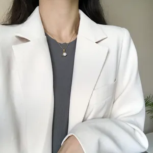 Primo piano di una collana di perle elegante con ciondolo a J, catena dorata da donna.
