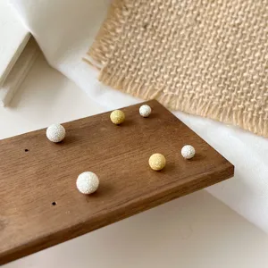 Sandblasted sphere ball stud earrings, featuring silver and gold finishes for daily wear.