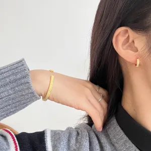 Elegantes goldenes geripptes Schmuckset mit Armreif, Ringen und Ohrringen für Damen.