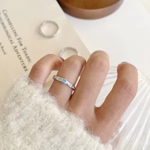 Silver heart ring detail showcasing sparkling blue zirconia and unique textured finish.