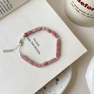 Detailed view of the pink rhodonite stone bead bracelet with silver accents and chain.