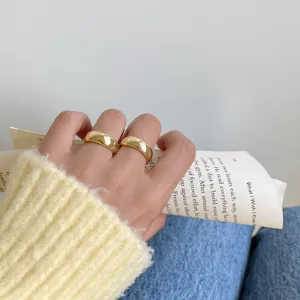 Minimalistische dicke gewölbte Goldringe mit glatter polierter Oberfläche und modernem Chic.