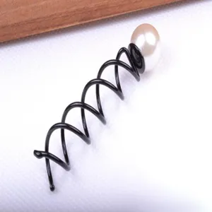 Gros plan d'épingle à cheveux spirale noire avec perle blanche pour chignon facile.
