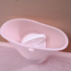 Pink PVC hot water bottle detail showing wide filling neck and white plug cap for winter.
