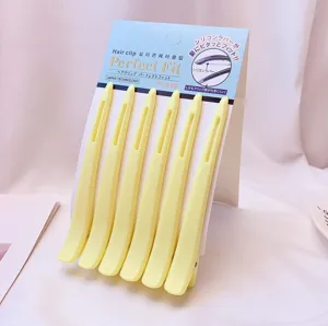 Close-up detail of yellow seamless hair clips set on display card for makeup and daily use.