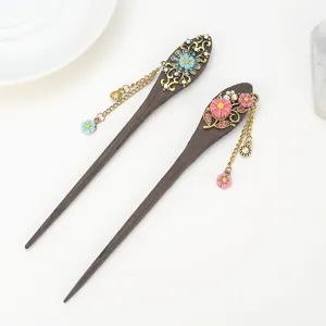 Wooden hairpin detail showing carved flower rhinestones and delicate metal chains tassels.