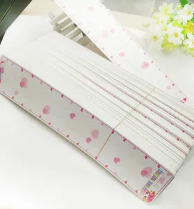 White paper hair accessory display cards with pink hearts for retail packaging and bow displays.