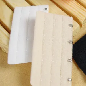Bra extension buckle detail view, showing white, nude and black colors with sturdy hook design.