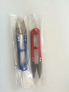 Detailed close-up view of portable U-shaped yarn scissors in protective plastic packaging.