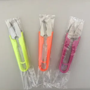 Close-up view of colorful U-shaped yarn cutting scissors in transparent protective bags.