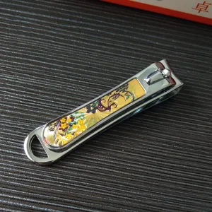 Detailed shot of large stainless steel nail clipper with decorative gold floral pattern design.