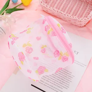 Cylindrical pink mesh laundry wash bag with delicate rose print and zipper for delicate clothes.