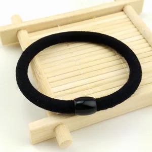 Vista dettagliata di un elastico per capelli spesso in nylon nero con perla brillante per lo styling