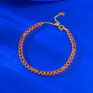 Gros plan élégant de bracelet tennis en argent 925 doré avec zircon rouge et chaîne réglable.