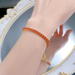 Gros plan détaillé du bracelet tennis étincelant en pierres rouges et réglable.