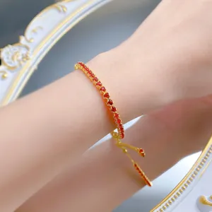 Gros plan détaillé du bracelet tennis en cristal rouge réglable au poignet, étincelant.