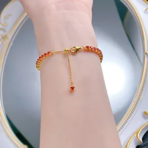 Gros plan d'un bracelet tennis en argent S925 avec pierres rouges et fermoir ajustable raffiné.