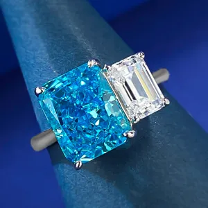 Primer plano detallado de un elegante anillo de dos piedras en plata 925 con gema azul y blanca.