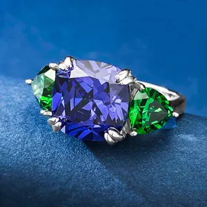 Dettaglio in primo piano dell'anello in argento S925 con tanzanite blu e pietre verdi.