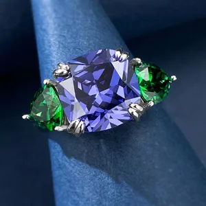 Primo piano dettagliato di un anello in tanzanite viola taglio radiante con pietre verdi laterali.