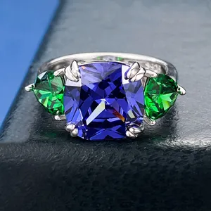 Elegante anello in argento S925 con pietra blu radiante e dettagli di zirconi verdi.
