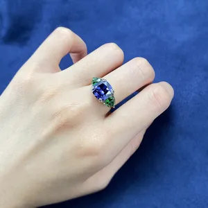 Vista dettagliata dell'elegante anello in argento con pietra blu e pietre verdi.