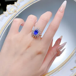 Nahaufnahme des eleganten silbernen Blumenrings mit einem strahlenden blauen Edelstein.