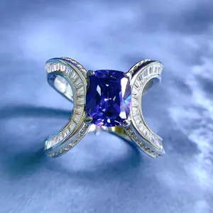 Primo piano dettagliato di un anello in argento con pietra viola taglio cuscino e zirconi brillanti.