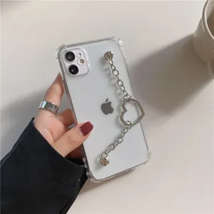 Clear phone case detail showcasing the elegant metallic heart chain wristband and transparent design.
