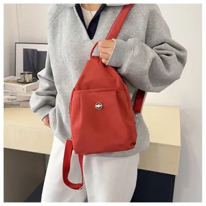 Detailansicht des roten Nylon-Minirucksacks mit kompaktem Design und Metallverschluss.