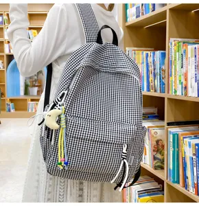 Detailansicht des lässigen schwarz-weißen Karo-Rucksacks mit Fronttasche und Anhänger